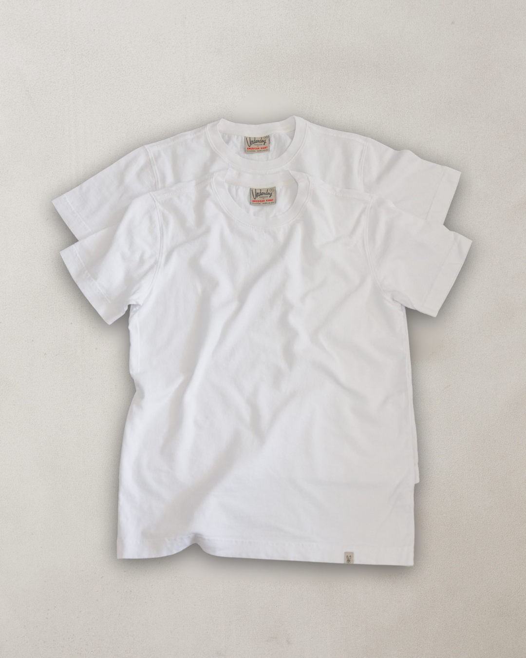White t-shirt with a brand logo on a light gray background