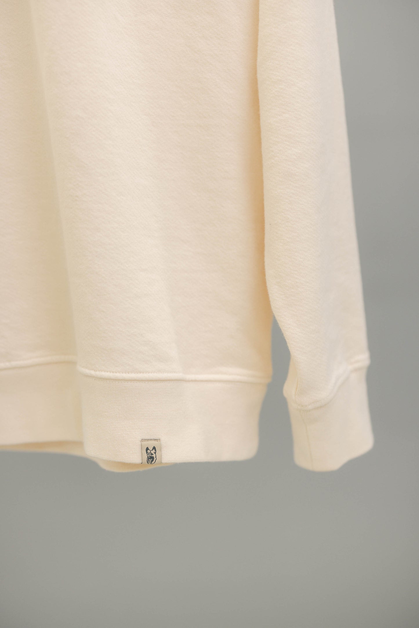 Close up of doghead woven label on ivory hem