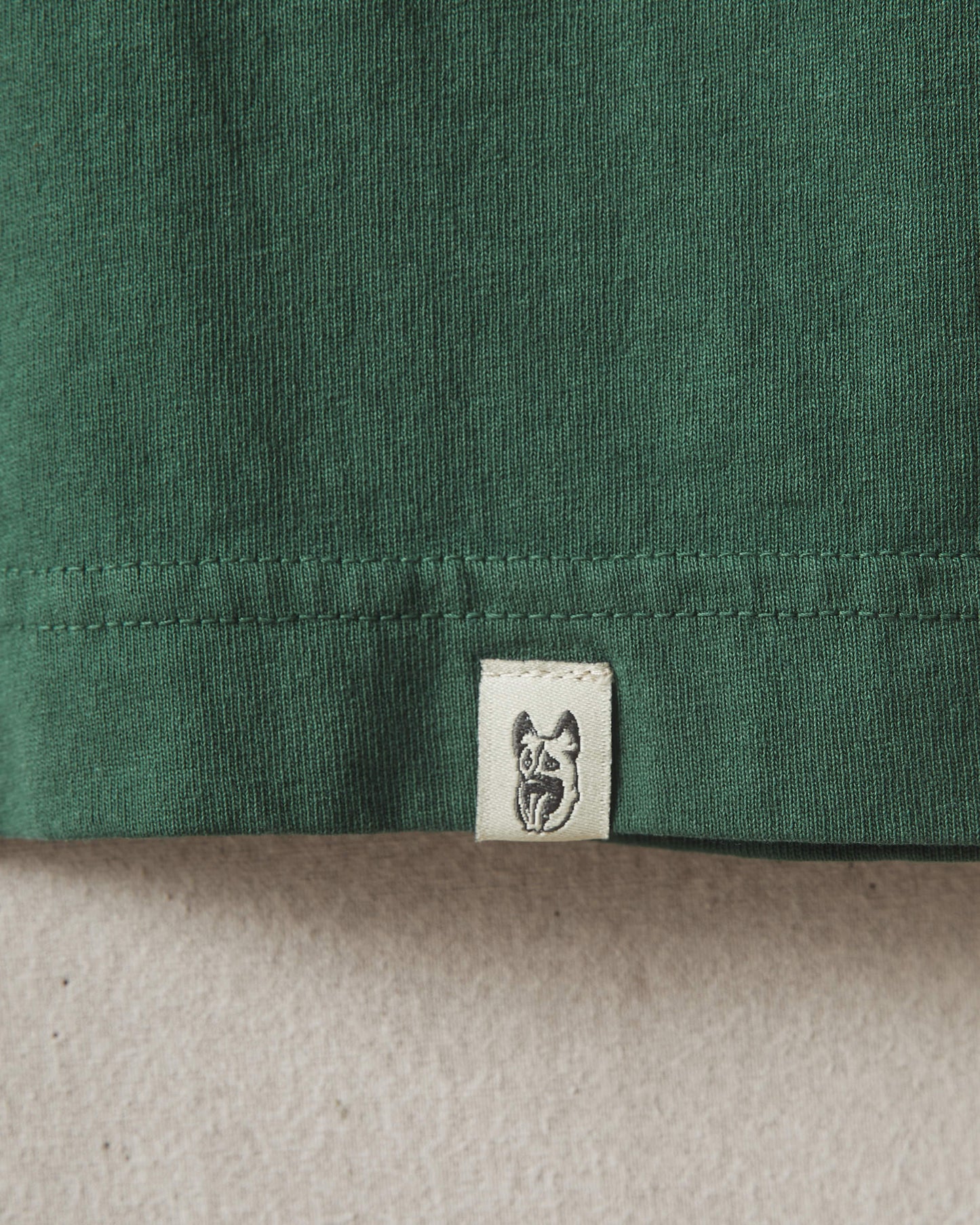 Green Underdog Apparel t-shirt featuring a white hand graphic and logo on the left sleeve.