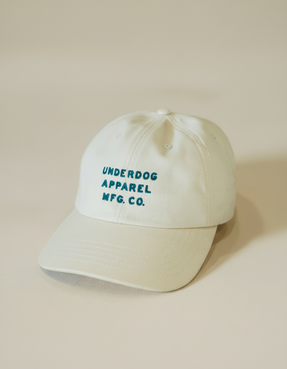 Beige cap with 'Underdog Apparel Mfg. Co.' text on a beige background
