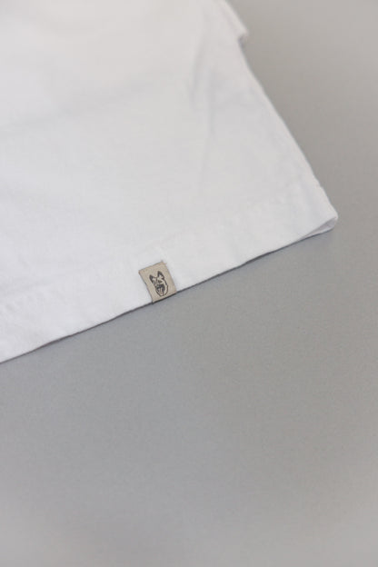 Hem of white tee with dog head label