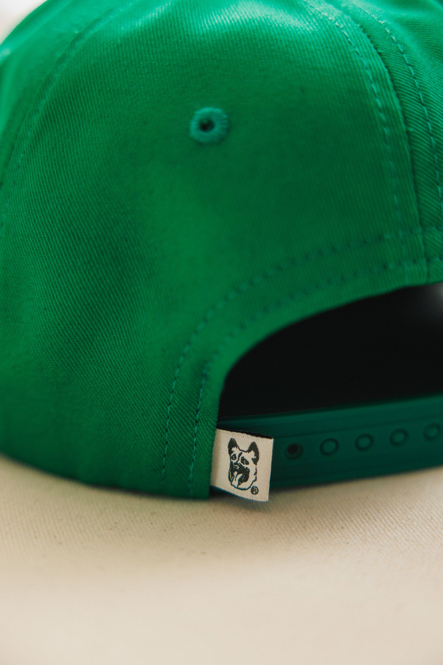 Green cap with a brand logo on a beige background