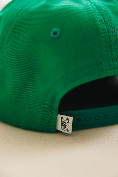Green cap with a brand logo on a beige background