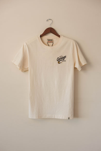 Beige t-shirt with a logo on a wooden hanger against a beige wall