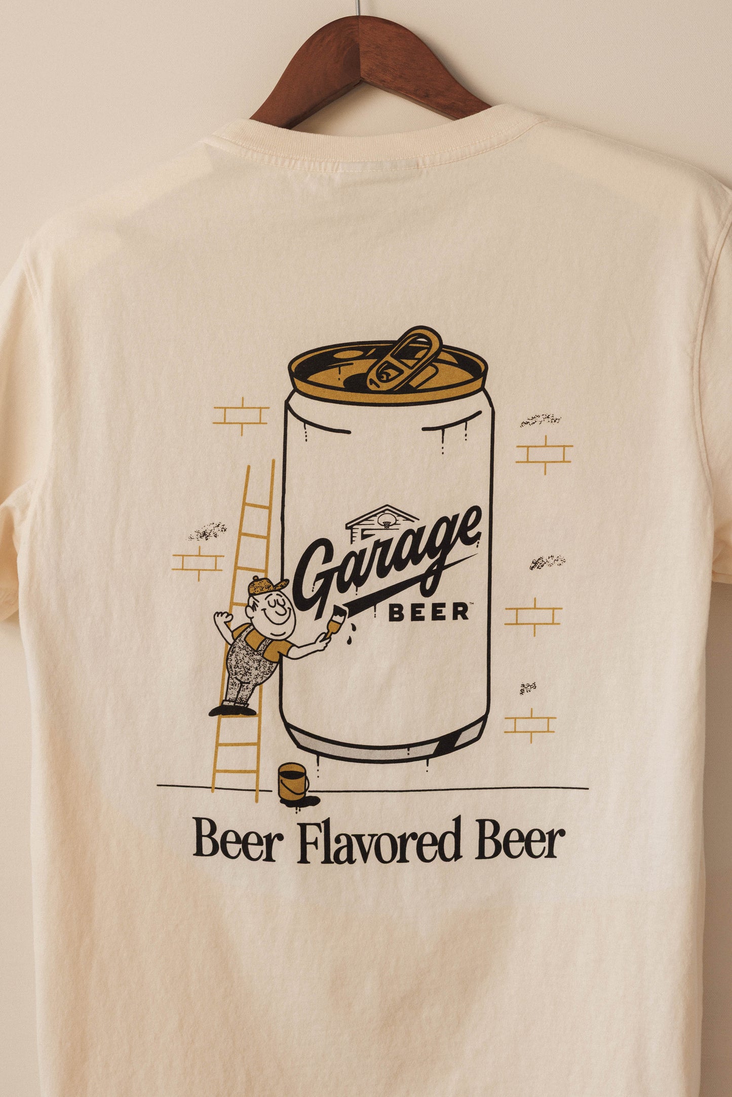 Beige t-shirt with 'Garage Beer' graphic on a hanger