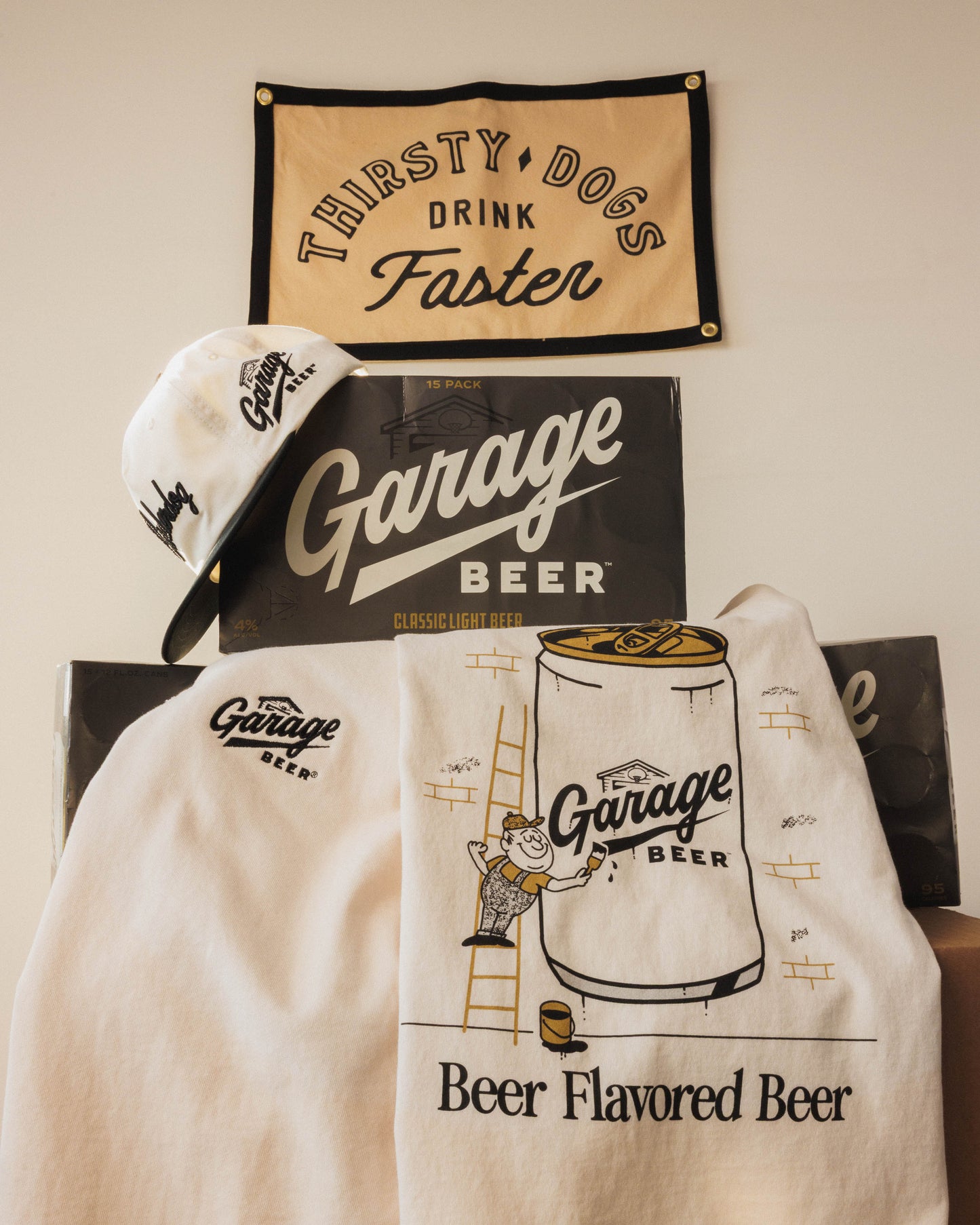 Garage Beer branded items including a hat, towel, and banner on a wall.