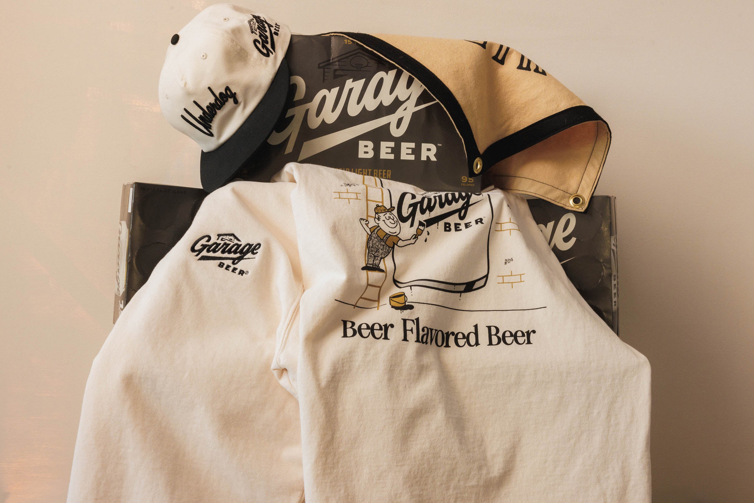 Garage Beer branded shirt and cap on a chair with a neutral background