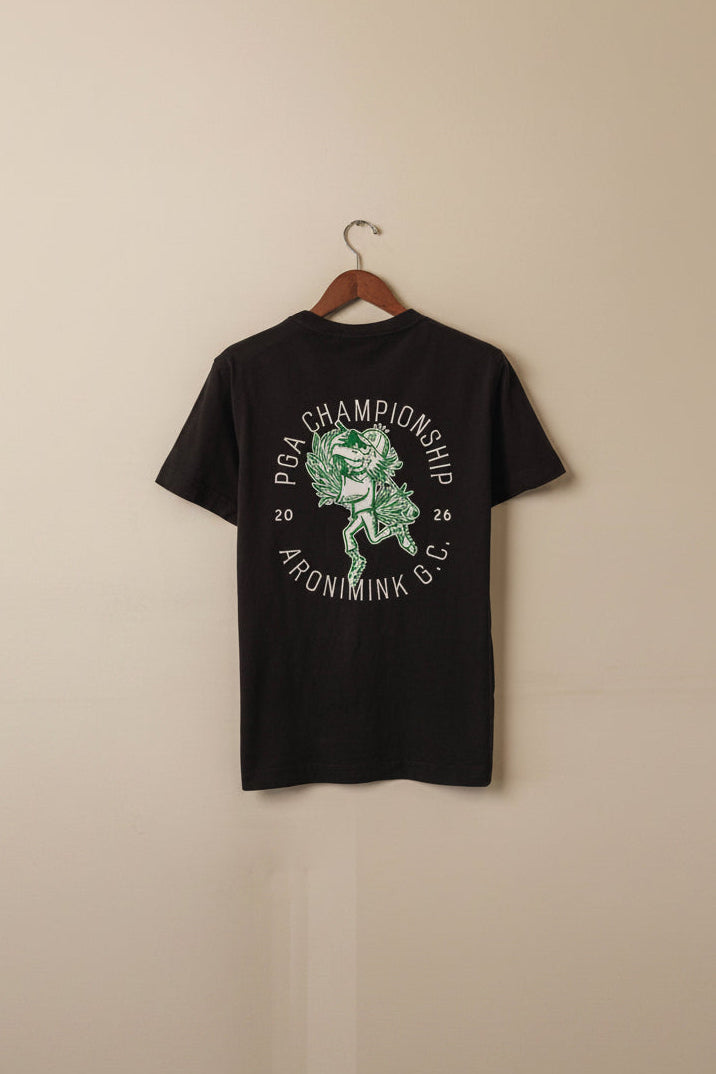 Black t-shirt with graphic design on a hanger against a beige wall