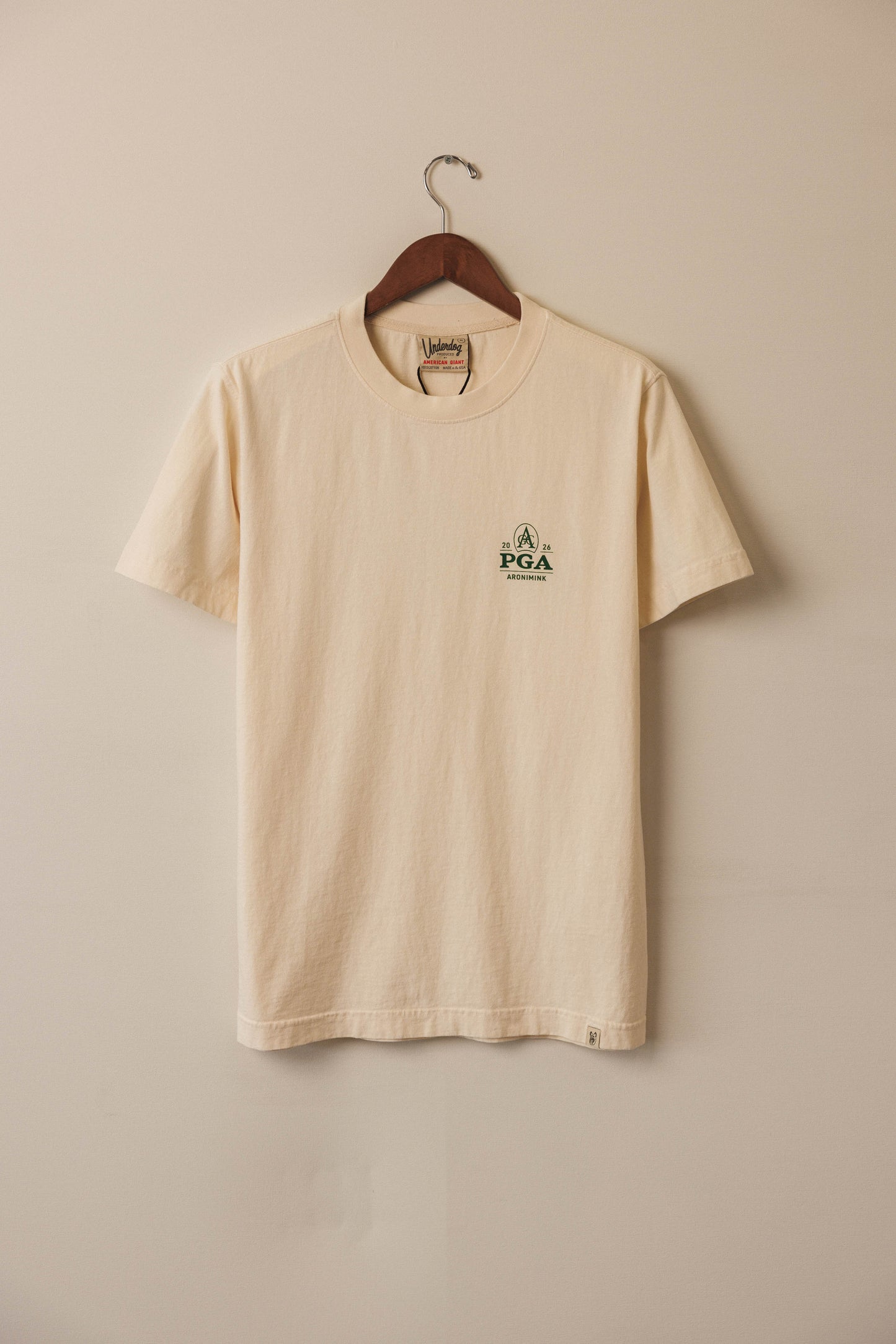 Ivory tee with green pga championship logo on eft chest