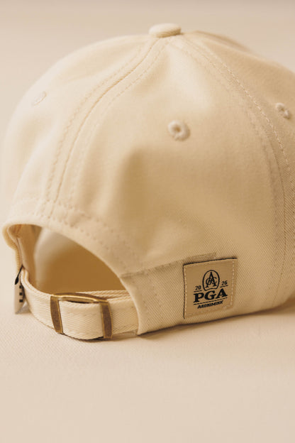 Beige cap with a PGA logo on a beige background