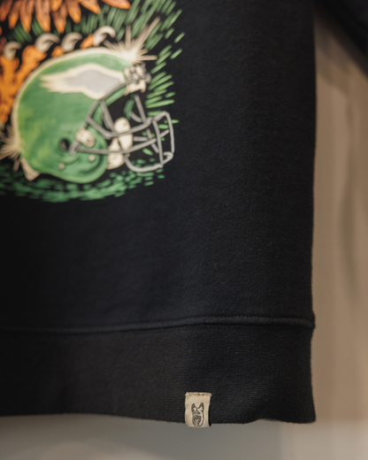 Black sweatshirt with a colorful graphic design on the sleeve, featuring a football helmet and leaves.